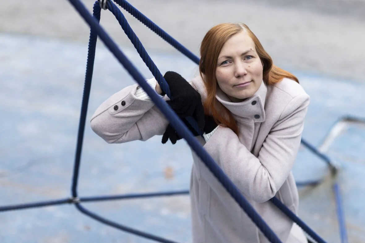 Planin vapaaehtoisena toimiva Kirsi Haramo nojaa kiipeilytelineeseen ja katsoo kameraan.