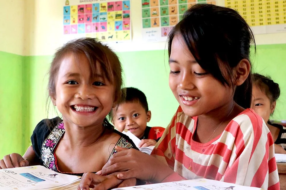 Laosilaisia lapsia opiskelemassa koululuokassa.