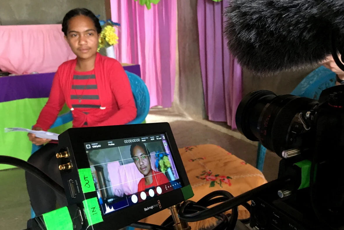Itätimorilainen Francelina istuu ja puhuu videokameralle, jonka monitorista näkyy Francelinan kuva.