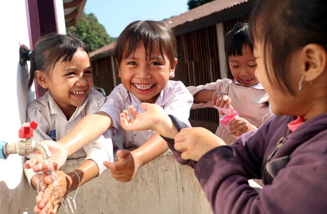 Laosilaisia lapsia pesemässä käsiään.