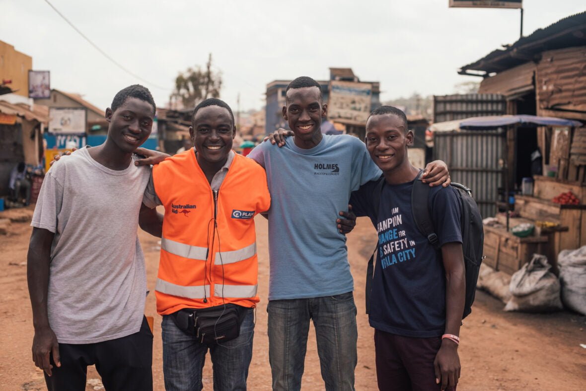 Ugandalaisnuoret poseeraavat yhdessä Kampalan kadulla.