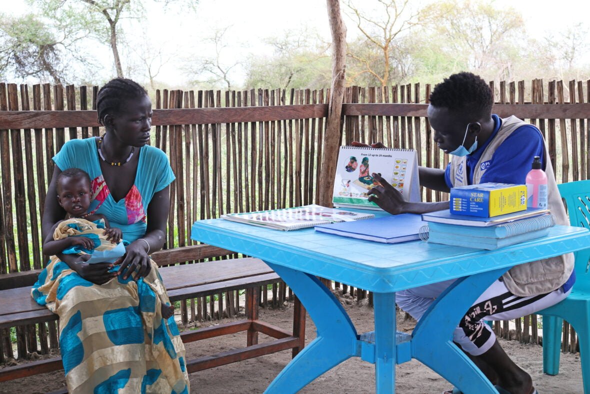 18-vuotias etiopialaisnainen vauvansa kanssa terveydenhoitajan puheilla terveysklinikalla Etelä-Sudanissa.