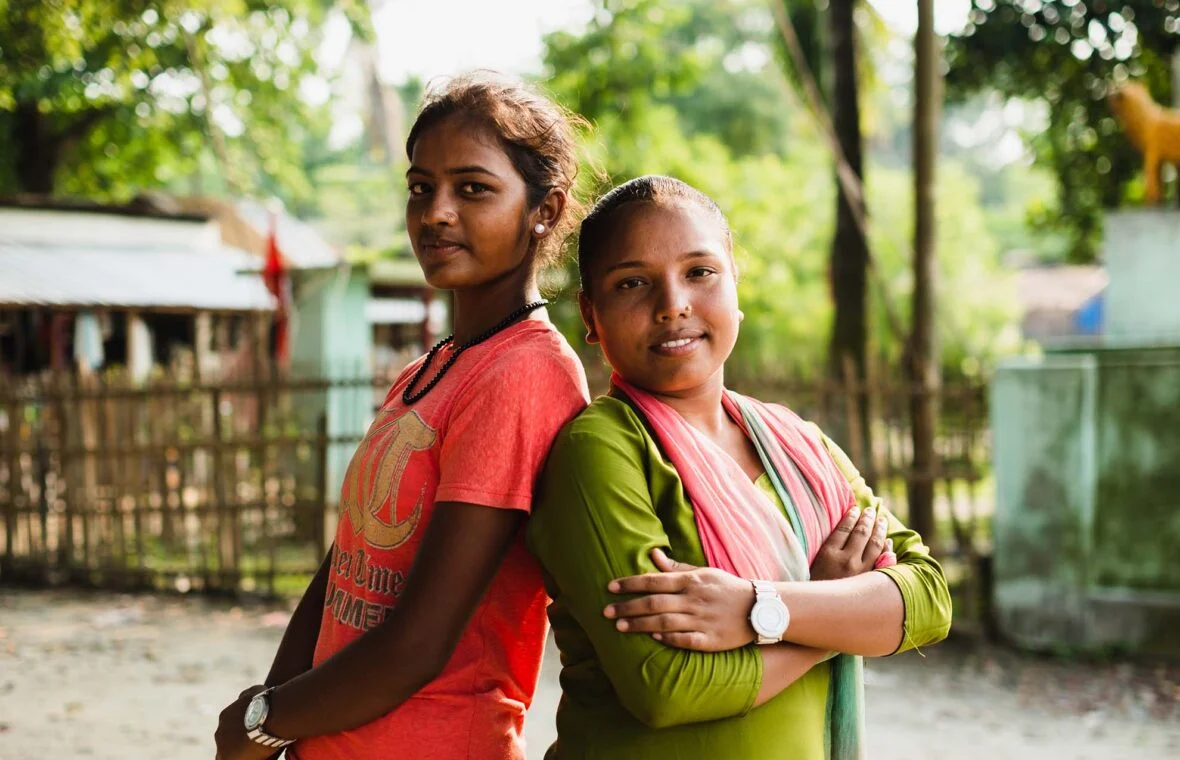 Nepalilaiset tytöt seisovat selät vastakkain.