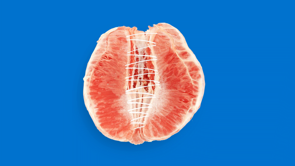 Sinisellä taustalla on halkileikattu veriappelsiini, jonka sisus on tikattu yhteen.