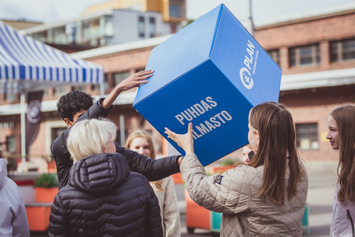 Joukko nuoria pitää käsissään isoa sinistä laatikkoa, jossa lukee isolla teksti: puhdas ilmasto