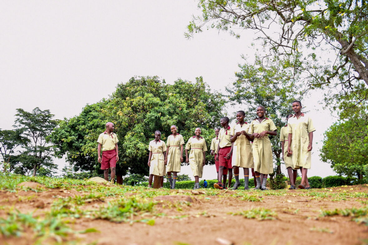 Ugandalaisia nuoria rivissä puiden vieressä.