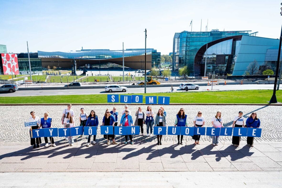 Plan Suomi ja nuoret aktivistit luovuttivat Suomi tyttöjen puolelle -vetoomuksen hallituksen muodostumisesta neuvotteleville päättäjille. Kuvassa joukko aktivisteja seisoo Eduskuntatalon edessä kädessään kirjain-kylttejä, joista muodostuu lause "Suomi tyttöjen puolelle".