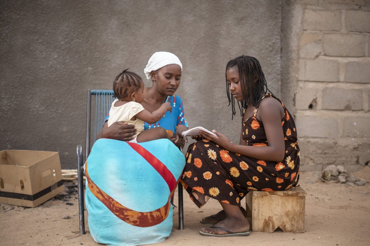 Malilainen Aminata näyttää äidilleen kirjaa.