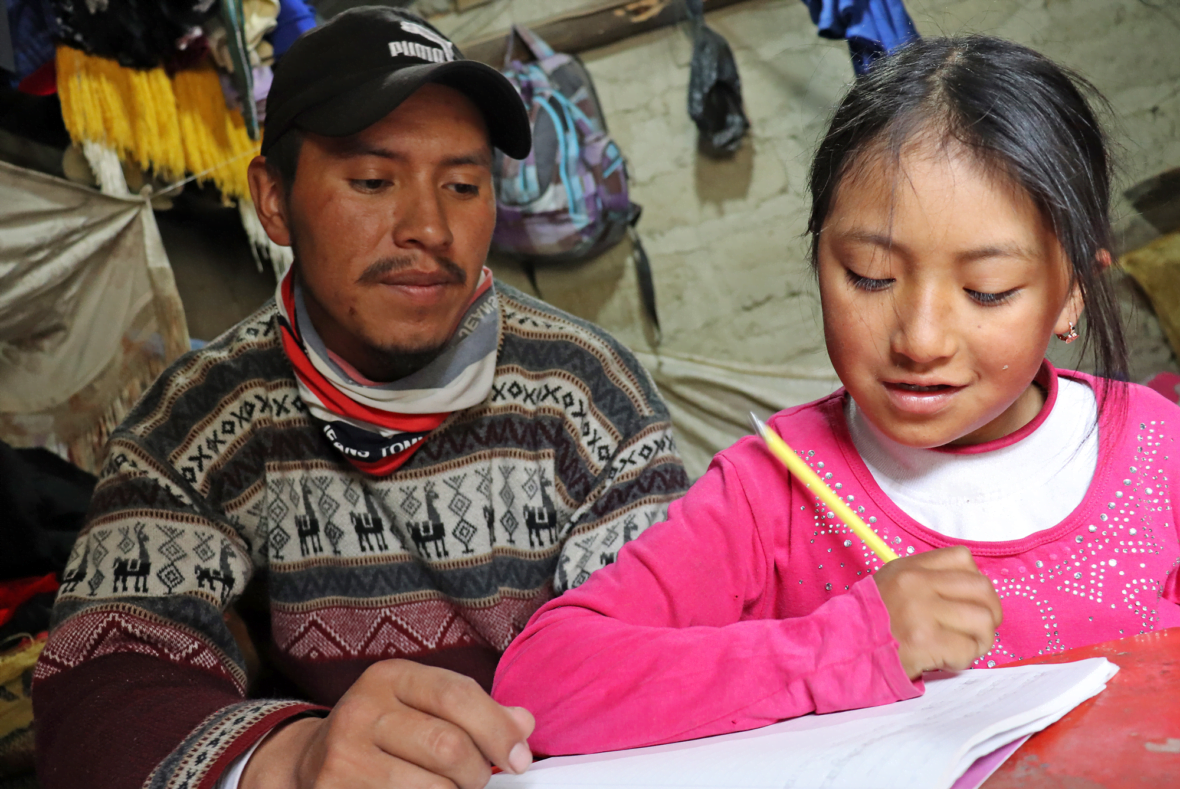 Ecuadorilainen isä ja tytär ovat yhdessä koulutehtävien äärellä.