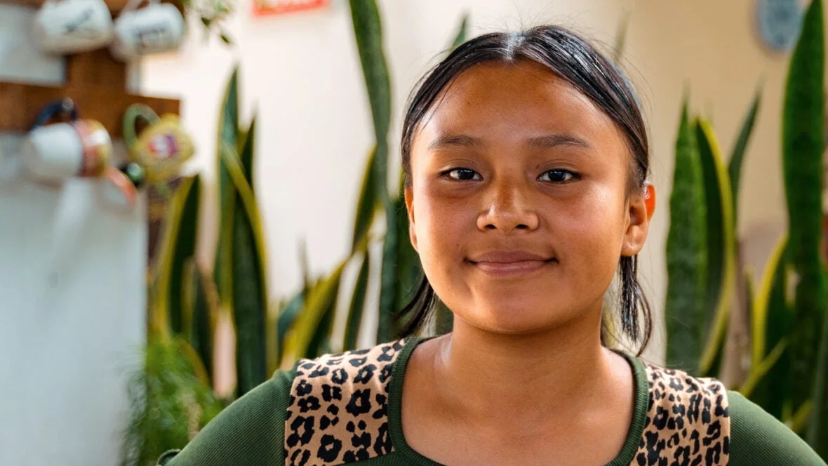 Guatemalalainen tyttö hymyilee kameralle.