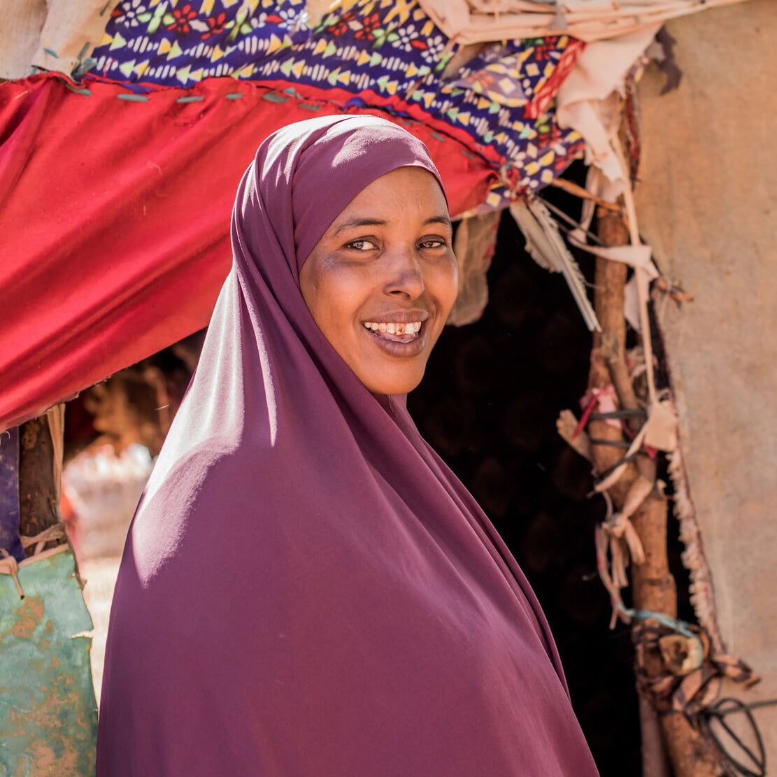 Somalialainen äiti Rahma, joka vastustaa tyttöjen sukuelinten silpomista, katsoo kuvassa hymyillen kameraan.