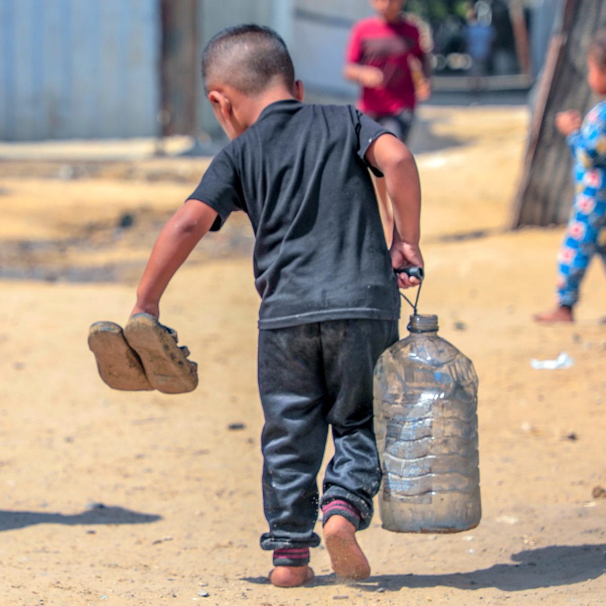 Gazalainen lapsi on hakenut avustuspisteeltä puhdasta vettä,