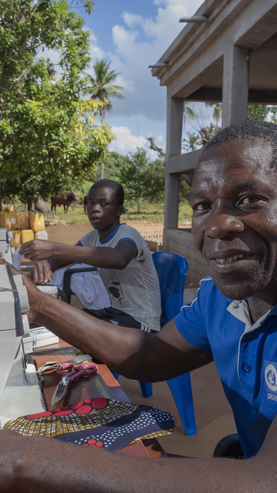 Mosambikilainen Pedro ompelee kuukautissiteitä.