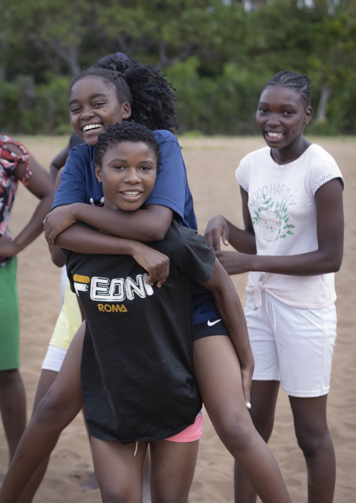 Mosambikilainen Eunice ystäviensä kanssa jalkapallokentällä.