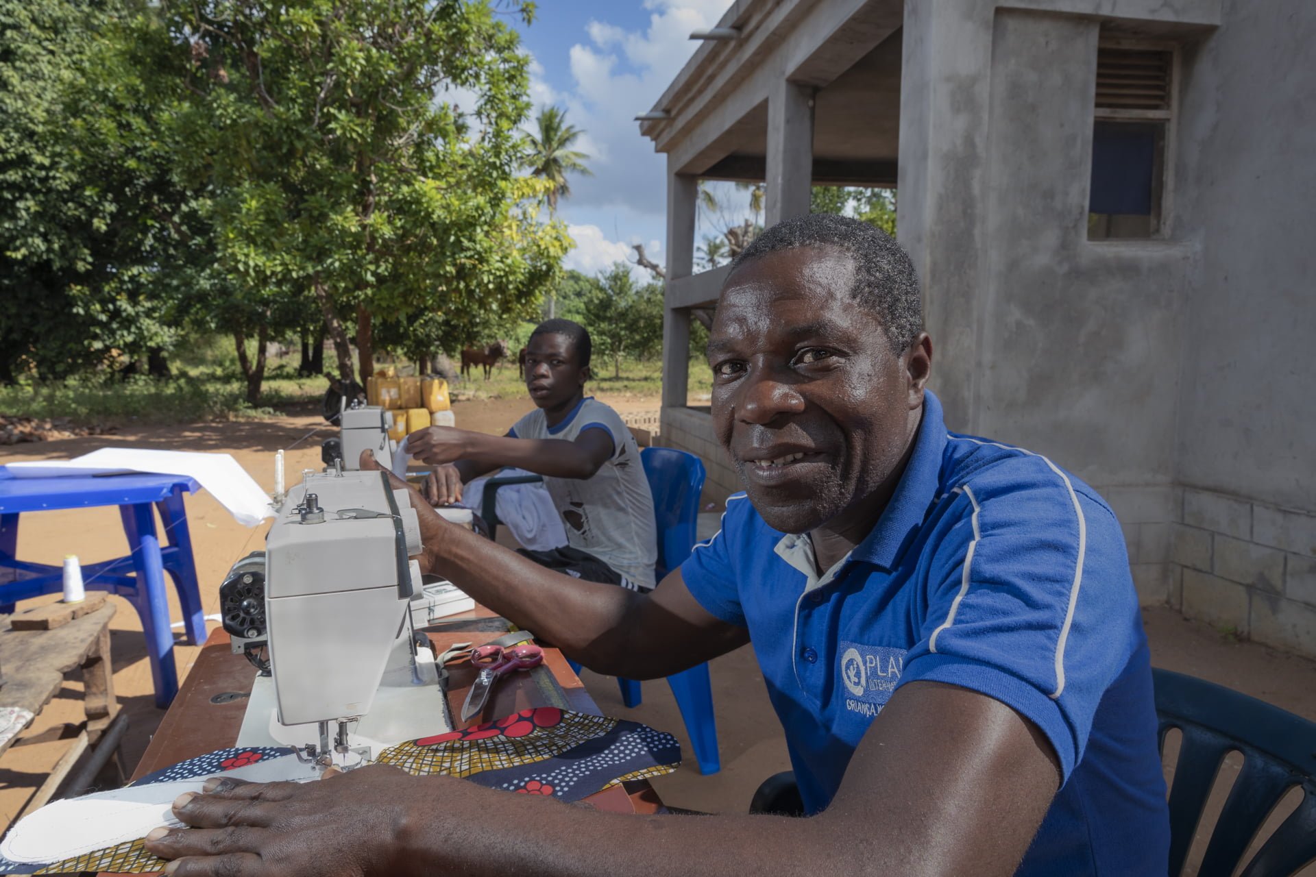 Mosambikilainen Pedro ompelee kuukautissiteitä.