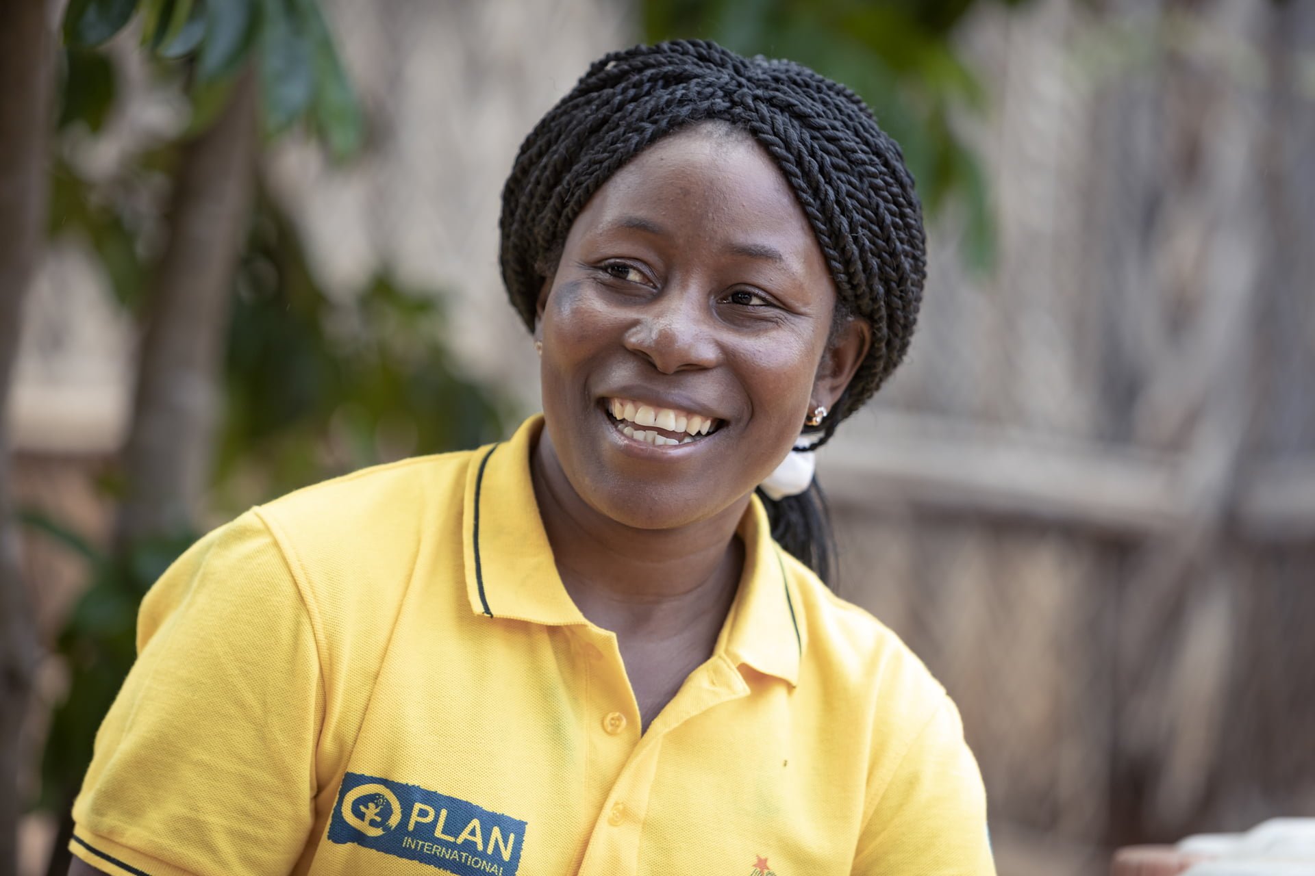 Mosambikilainen Helena Planin paita päällään hymyilee.
