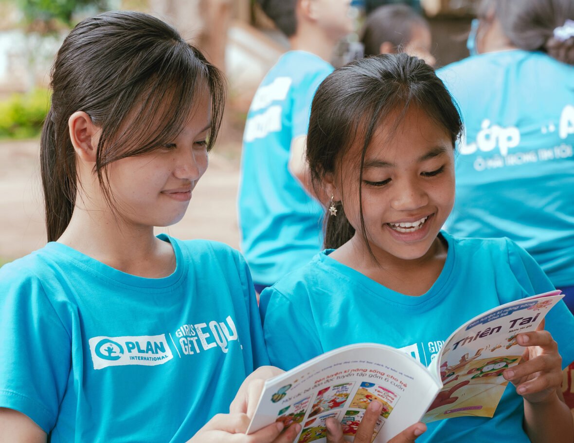 Vietnamilaiset tytöt lukevat yhdessä kirjaa.