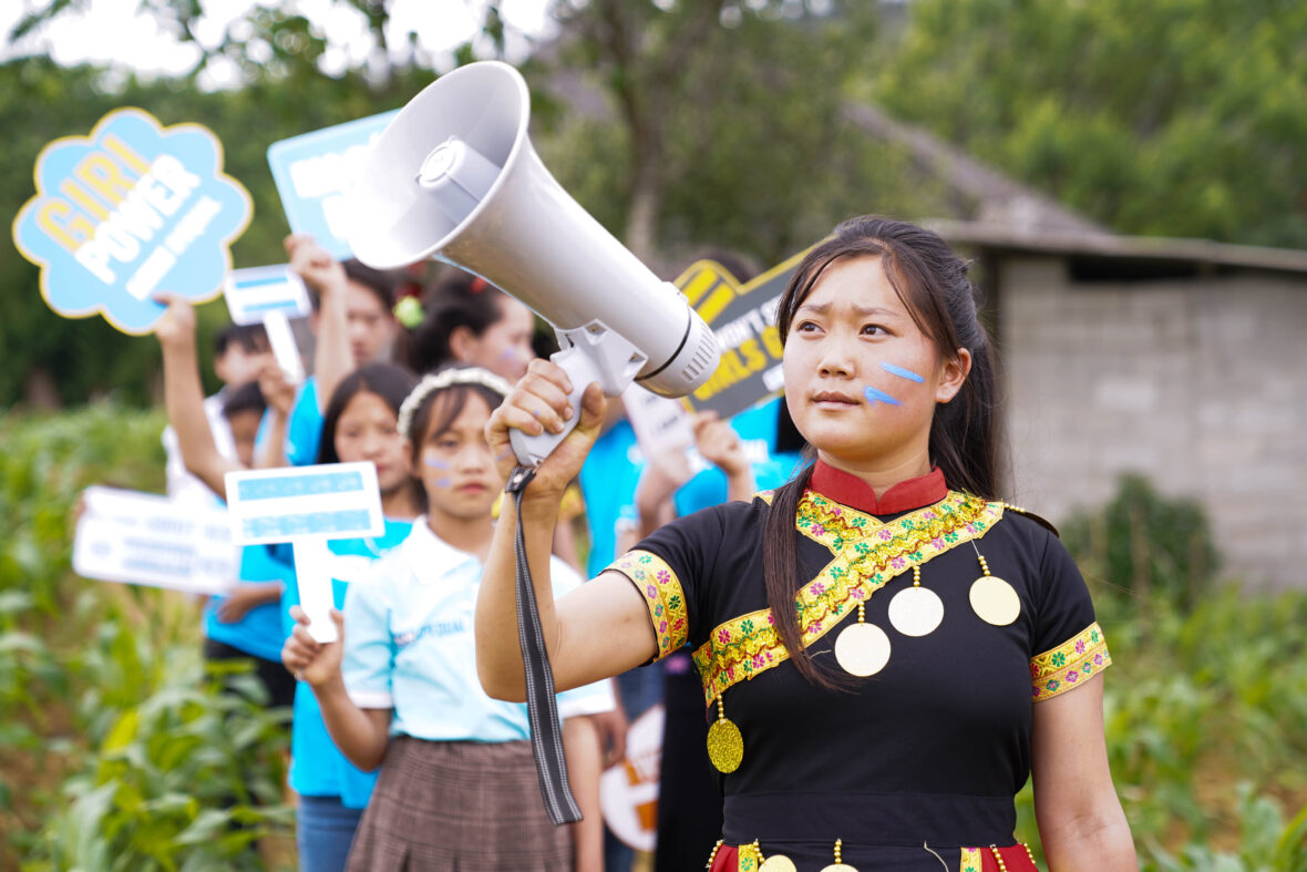 Nuorten ryhmä Vietnamissa vaatii tasa-arvoa. Nuorilla on megafoni ja kyltit käsissään.