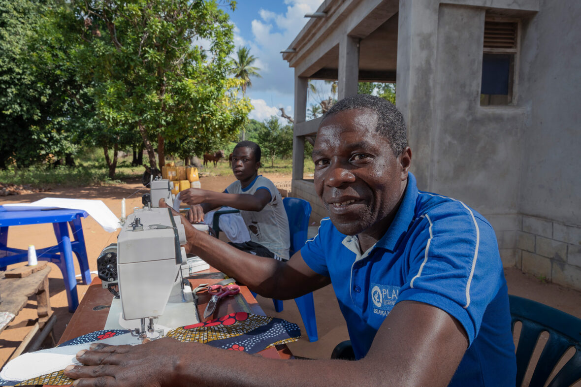Mosambikilainen Pedro istuu ompelukoneensa ääressä ompelemassa kestokuukautissuojia.