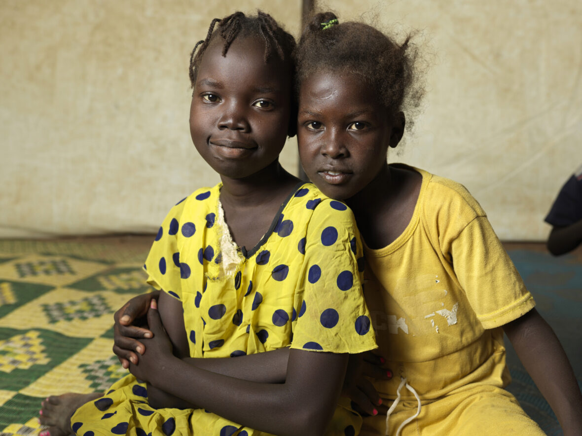 Lena, 12, ja Rumaisa, 10, käyvät päivisin leikkimässä Planin perustamassa lapsiystävällisessä tilassa Renkin kauttakulkukeskuksessa Etelä-Sudanissa.