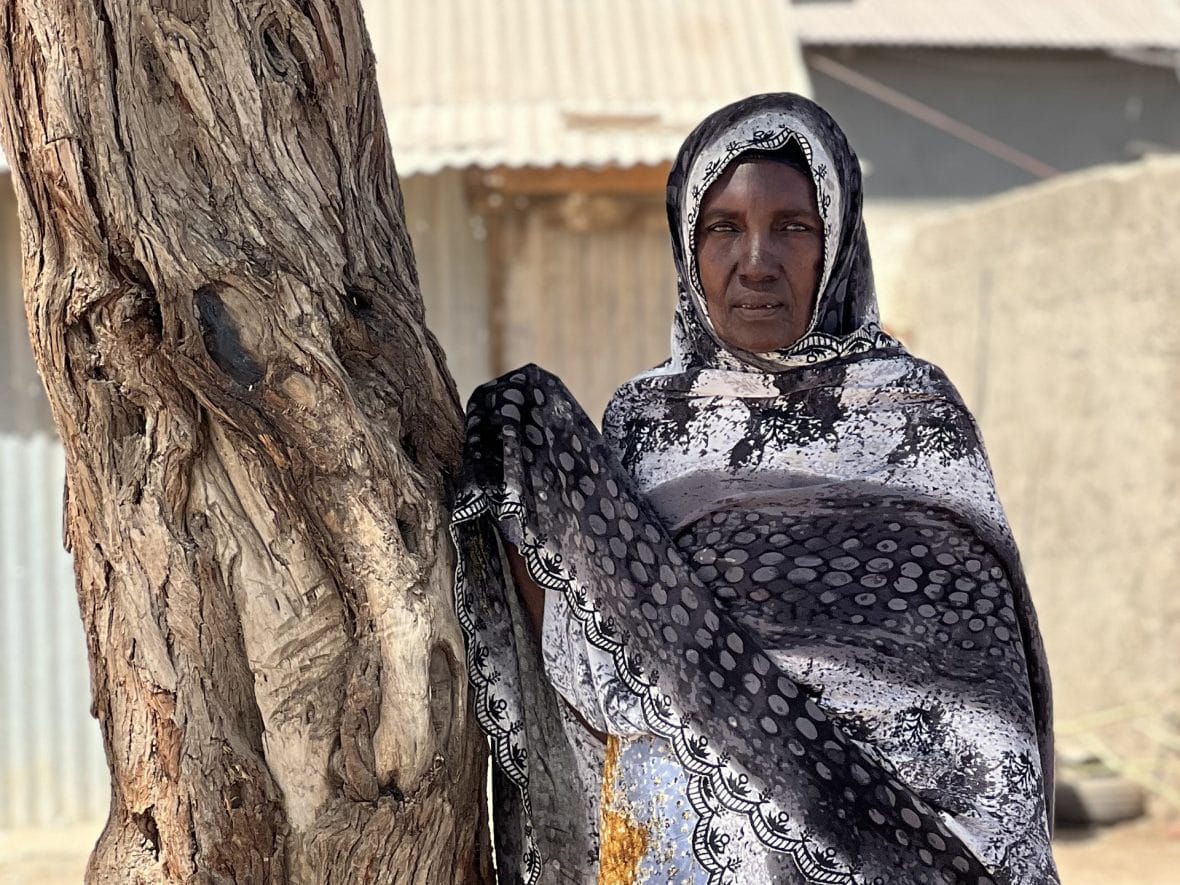 Somalialaisäiti nojaa puuta vasten pakolaisleirillä.