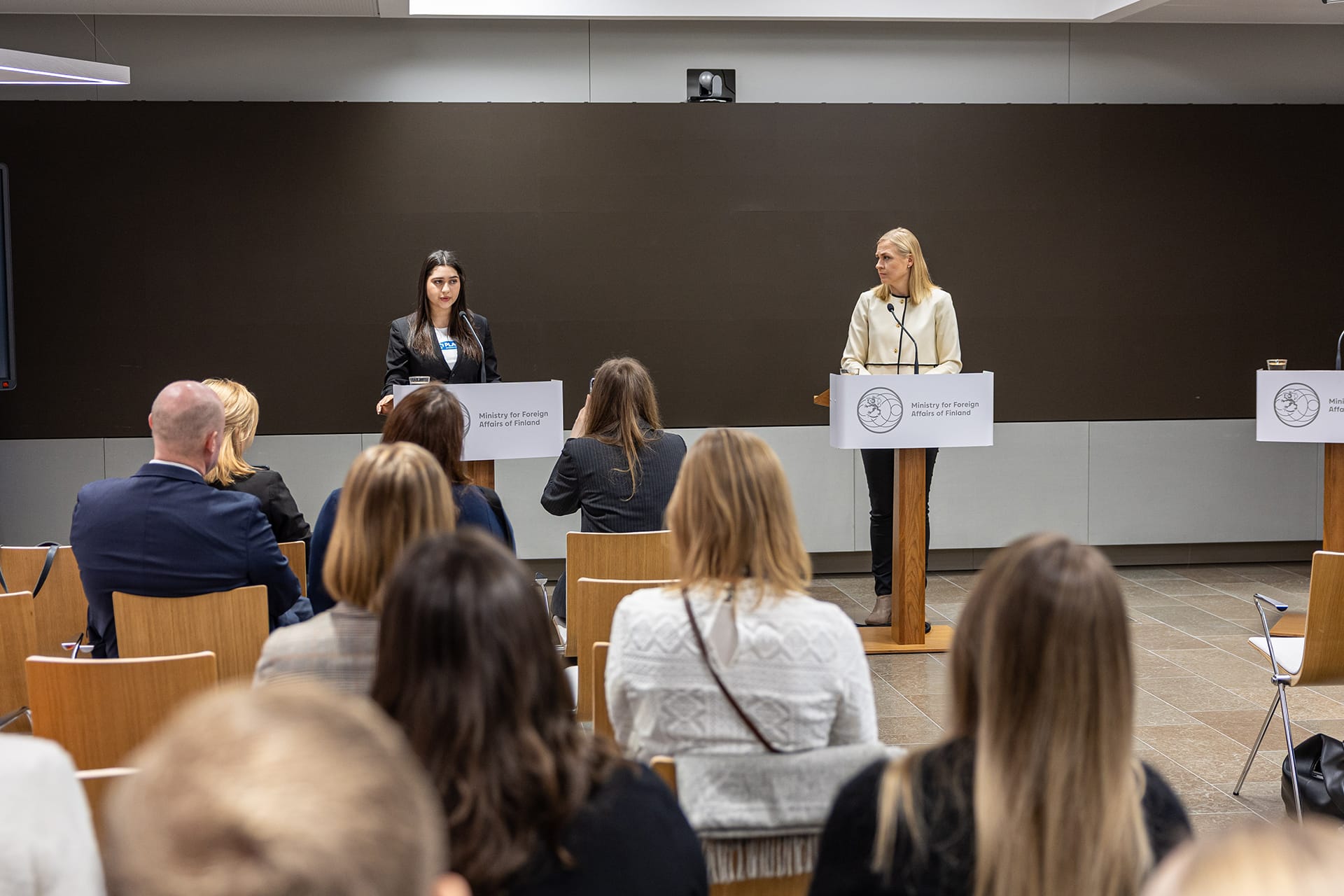 GirlsTakeover-valtaaja Natasha Al-Zeilaa ja ulkoministeri Elina Valtonen puhumassa yleisölle. Kuva: Ulkoministeriö
