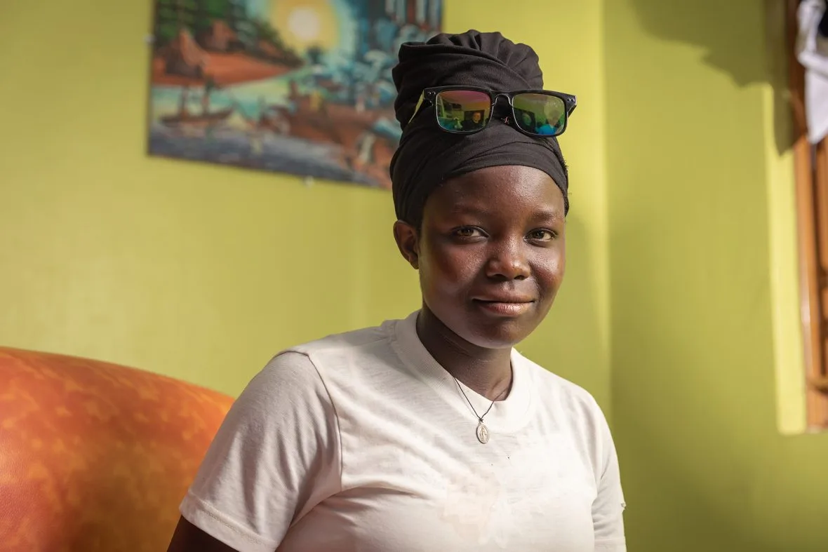 Ugandalainen Felista istuu nojatuolissa ja katsoo määrätietoisesti kameraan.