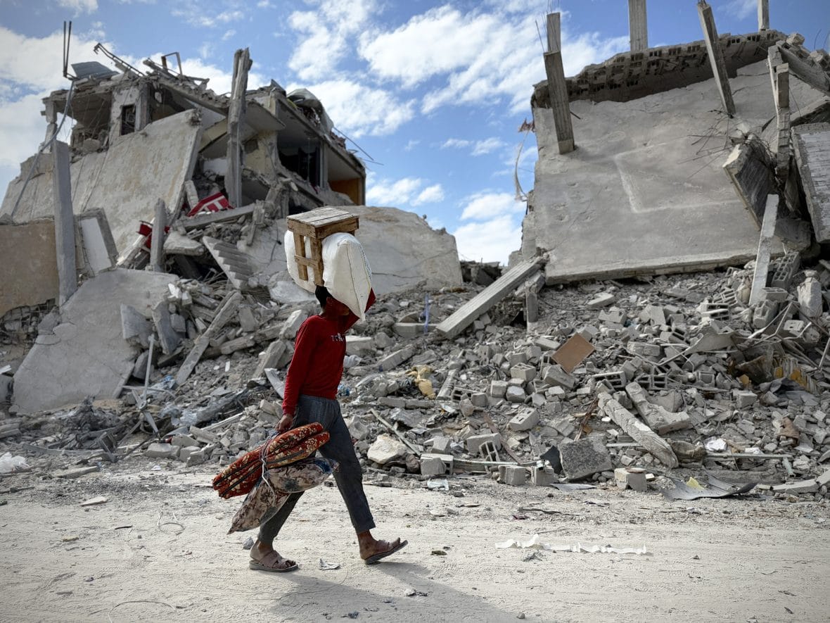 Henkilö kävelee raunioituneessa kaupungissa Gazassa.