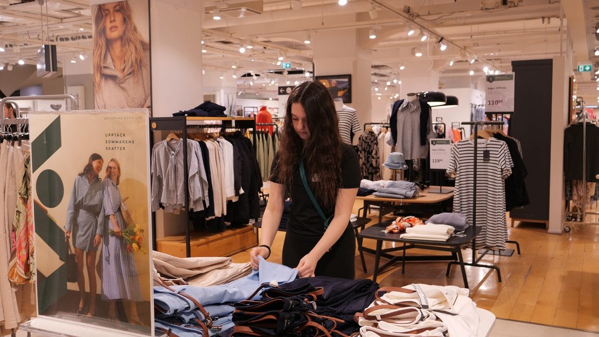 Nuori kesätöissä vaatekaupassa