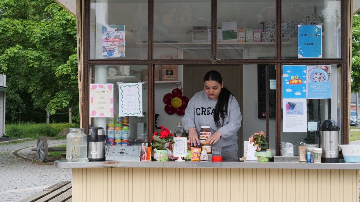 Nuori kesätöissä kioskilla