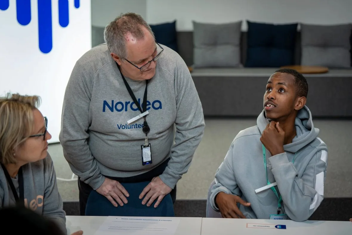 Nuoret ja Nordan työntekijät keskustelevat Planin ja Nordean yritystapahtumassa.