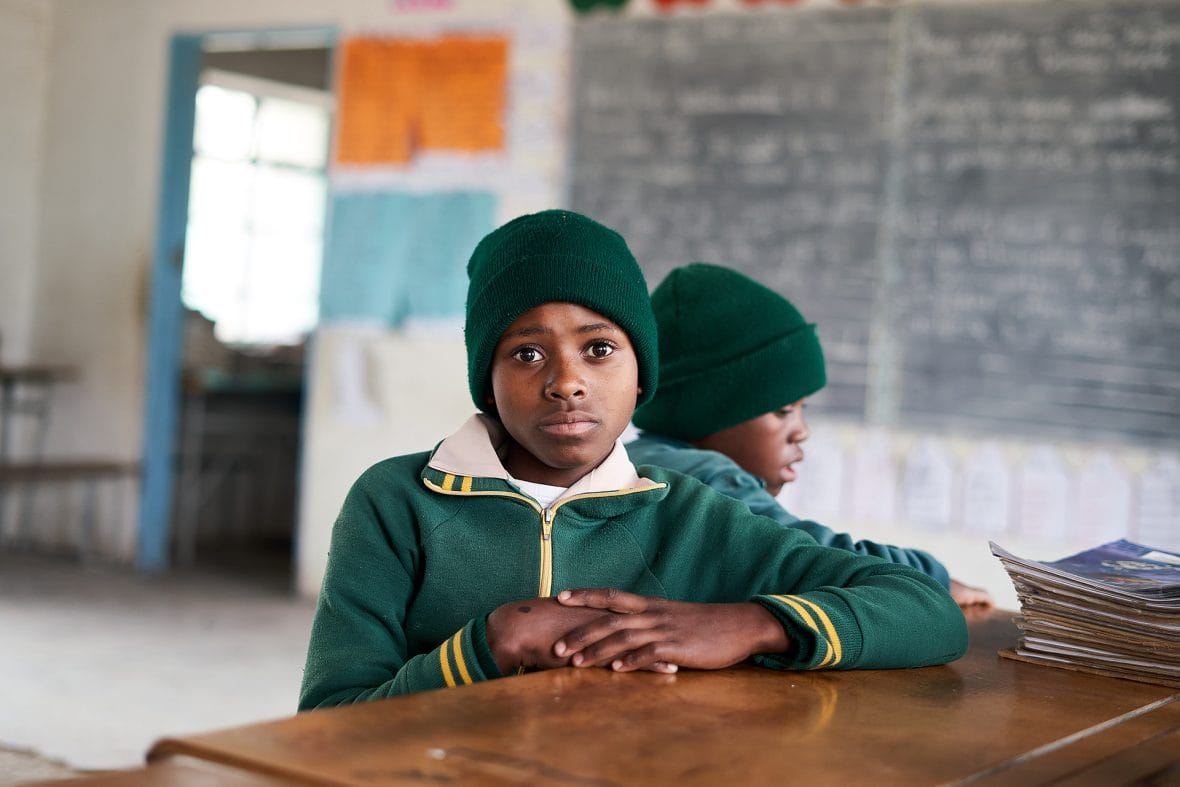 Zimbabwelainen Kimberly istuu koulun luokkahuoneessa.