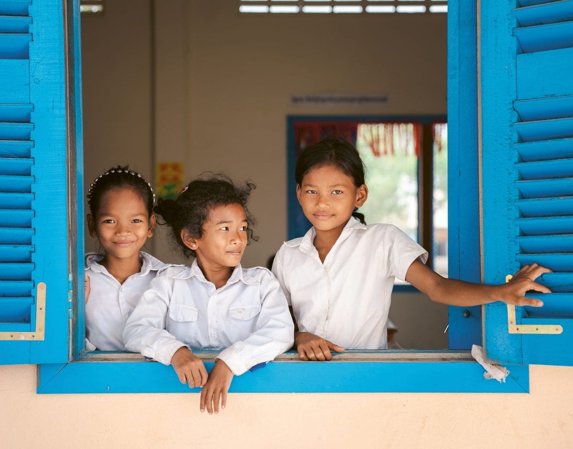 Koululaiset katsovat ulos koululuokan ikkunasta.