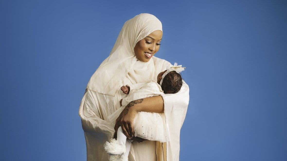 Hankkeen äiti pitää sylissä vauvaansa ja katsoo tätä hymyillen. 