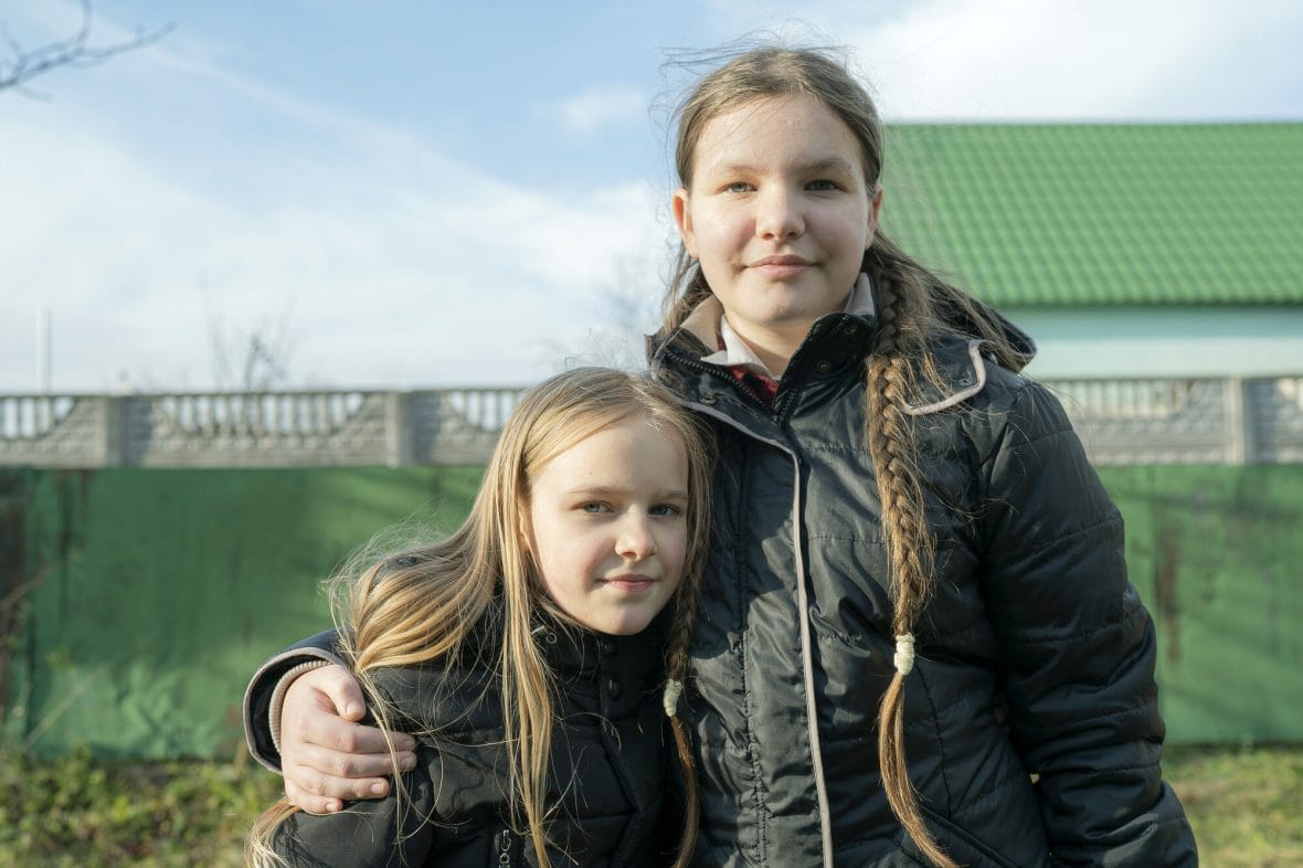 Ukrainalaiset tytöt seisovat kädet toistensa harteilla ja katsovat kameraan.